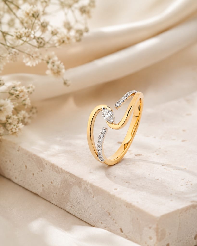 Aarvi yellow gold bypass diamond ring on travertine
