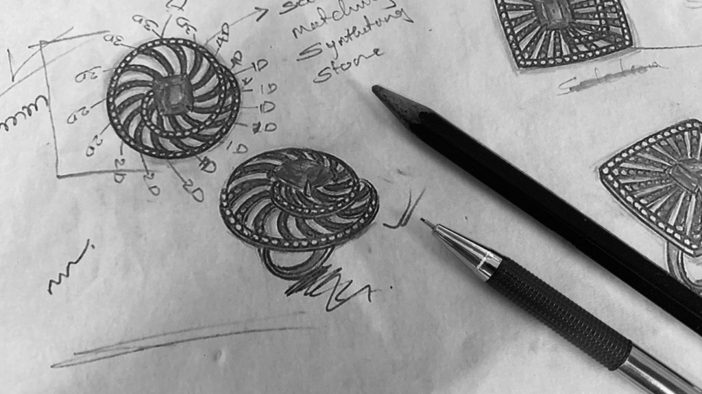 Master artisan drawing a manual jewellery sketch with technical pencil